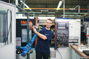 Mann mit Roboterarm in Werkstatt