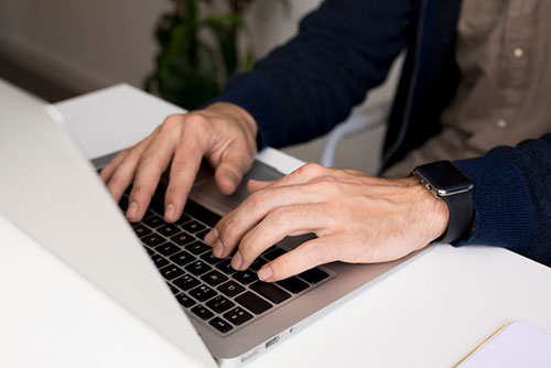 Person types on laptop keyboard