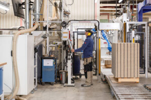 Arbeiter bedient Maschine in Fabrikhalle.