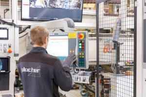 Mitarbeiter bedient Maschinensteuerung in Fabrik